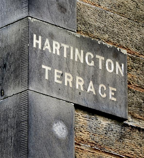 White letters painted on dark discoloured masonry.