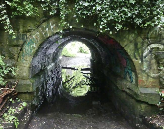 Flooded path beneath railway bridge.